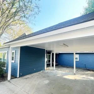 Navy-blue lap siding with carport after exterior repaint