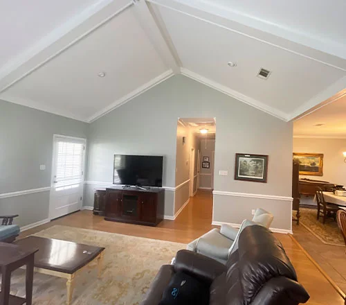 Finished interior painting job — bright living room with vaulted ceiling and crown molding